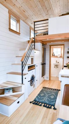 a kitchen and stairs in a tiny home with wood floors, white walls, and wooden flooring