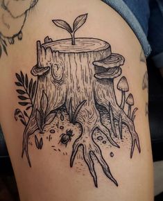 a tree stump with mushrooms and plants growing out of it's roots is shown in this tattoo design