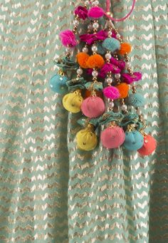 a close up of a person wearing a dress with buttons and beads on the back