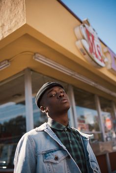 a man standing in front of a mcdonald's with his eyes closed and looking up