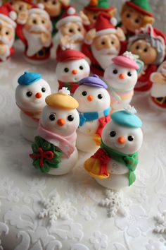 a group of snowman figurines sitting on top of a white tablecloth