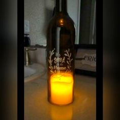 a lighted candle in a bottle sitting on a counter