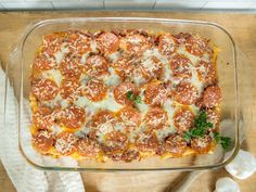 a casserole dish with meat and cheese in it on top of a wooden table