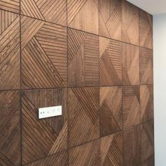 a wooden wall with a light switch on it and some wood panels in the background