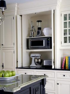 a microwave oven sitting on top of a counter next to an apple and other kitchen items