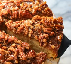 a cake with pecans on top is cut into slices