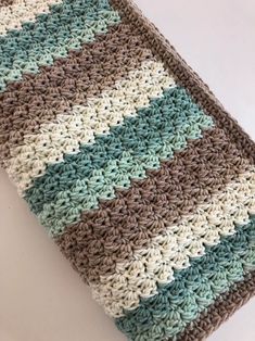 a crocheted blanket is laying on the floor