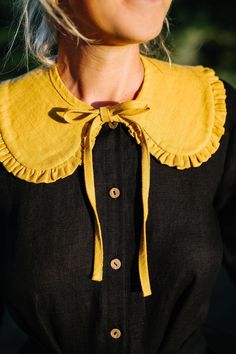 a woman with blonde hair wearing a black and yellow dress