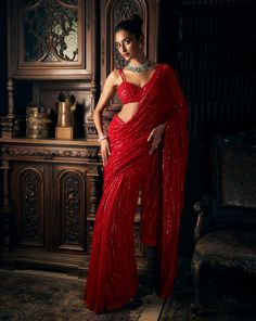 This red net saree features tonal sequin embroidery in a linear pattern. It is paired with a fully embroidered strappy blouse.From Seema Gujral's Kashish collection DELIVERY TIMEPlease allow 8-12 weeks for your outfit to arrive. FABRIC DETAILSNet Professional cleaning only. Red Net Saree, Red Sequin Saree, Red Saree Wedding, Strappy Blouse, Seema Gujral, Red Sari, Sequin Saree, Fancy Sarees Party Wear, Simple Sarees