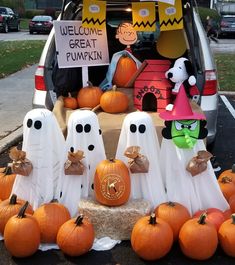 halloween decorations in the trunk of a car with ghost figures and pumpkins on display