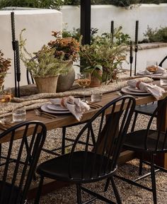 an outdoor table set with plates and place settings