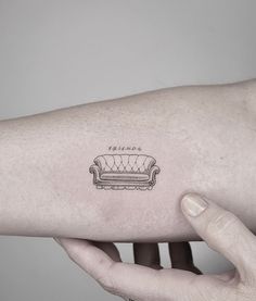 a person's arm with a couch tattoo on the left side of their arm