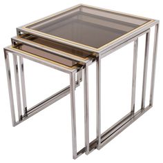 three metal and glass nesting tables on white background