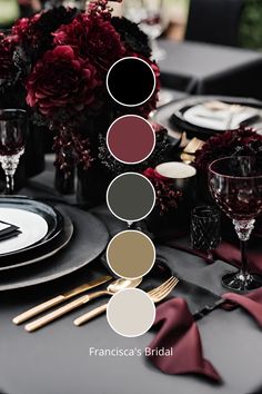 the table is set with black and white plates, silverware, and red flowers