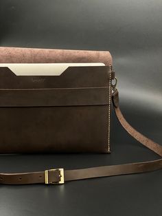 a brown leather purse sitting on top of a black table next to a white wall