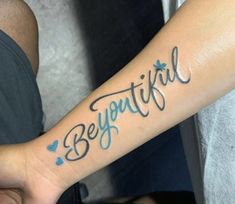 a person with a tattoo on their arm that says beautiful