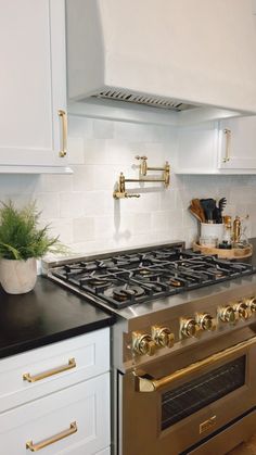 a stove top oven sitting inside of a kitchen next to white cabinets and counter tops