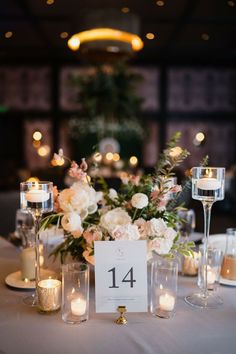 the table is set with candles, flowers and menu cards for an elegant wedding reception