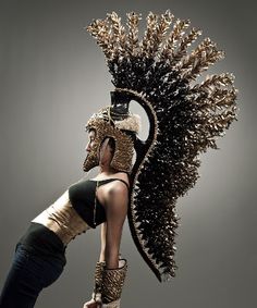 a woman in black and white is doing a trick on a skateboard with an elaborate headdress