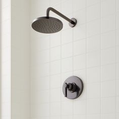 a shower head with thermostaer and faucet on it in a white tiled bathroom