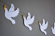 paper doves hanging on a line with clothes pins