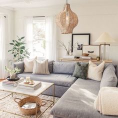 a living room filled with lots of furniture and pillows on top of a rug next to a window