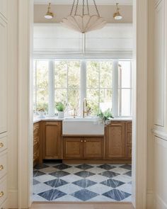 an open door leading to a kitchen with checkered tile flooring and white walls