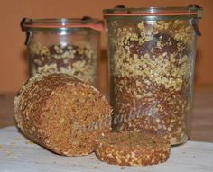 a loaf of bread sitting on top of a table next to two jars filled with food