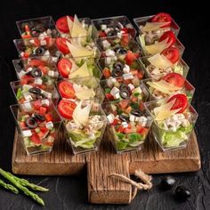 a wooden board topped with lots of salads and veggies on top of it