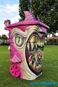 a large trash can painted like a monster with big eyes and fangs on it's face