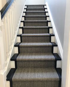 a set of stairs leading up to the second floor with black handrails and carpet