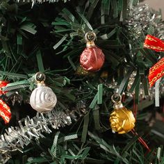 a christmas tree with ornaments hanging from it's branches and tinsel on top