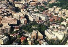 an aerial view of a city with lots of tall buildings and trees in the foreground