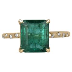 Displayed is a modern emerald and diamond solitaire engagement ring/right-hand ring in 14K yellow gold. This gorgeous solitaire ring carries a 2.60-carat emerald in a four-prong setting. Fully faceted, this gemstone showcases excellent shine. The emerald has very good clarity with minor flaws that are normal in all genuine emeralds. Diamonds are sprinkled into the gold shank. Minimalist and beautiful. Setting Style: Prong/Bezel Setting Material: 14K Yellow Gold Main Stone: Emerald Shape: Emerald Wedding Ring Ideas, Right Hand Rings, Engagement Wedding Ring, Diamond Solitaire Engagement Ring, Ring Ideas, Zambia, Jewelry Rings Engagement, Diamond Shape, Solitaire Engagement