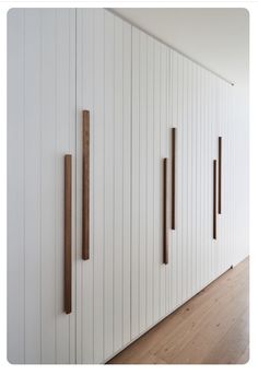 a room with white walls and wood trimmings on the wall, along with wooden flooring