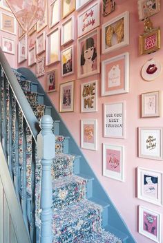 the stairs are decorated with pictures and frames