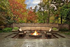 an outdoor fire pit with seating around it