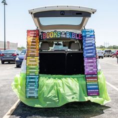 the back end of a vehicle with books stacked on it's trunk in a parking lot