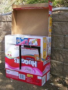 an open box sitting on the ground next to a brick wall