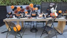 the table is set up with decorations and pumpkins for halloween dinner or party guests to enjoy