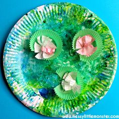 paper plates with flowers on them sitting on a blue surface