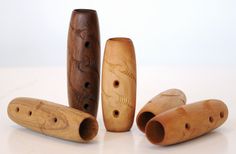 three wooden flutes are lined up on a table with holes in the top and bottom