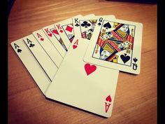 four playing cards sitting on top of a wooden table