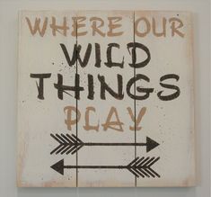 there is a sign that says where our wild things play with arrows on the wall