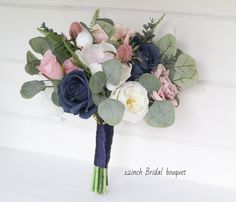 a bridal bouquet with blue, pink and white flowers on it's side