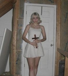 a woman standing in front of a door with a cross on it's chest