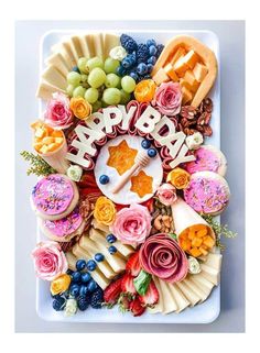 a white plate topped with lots of different types of food and the word happy spelled out in letters