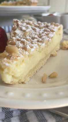 a piece of pie sitting on top of a white plate next to a strawberries