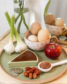 an assortment of food on a plate with some vegetables and eggs in the bowl next to it