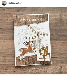 a christmas card with an image of a deer and presents on the wooden background, which reads merry christmas